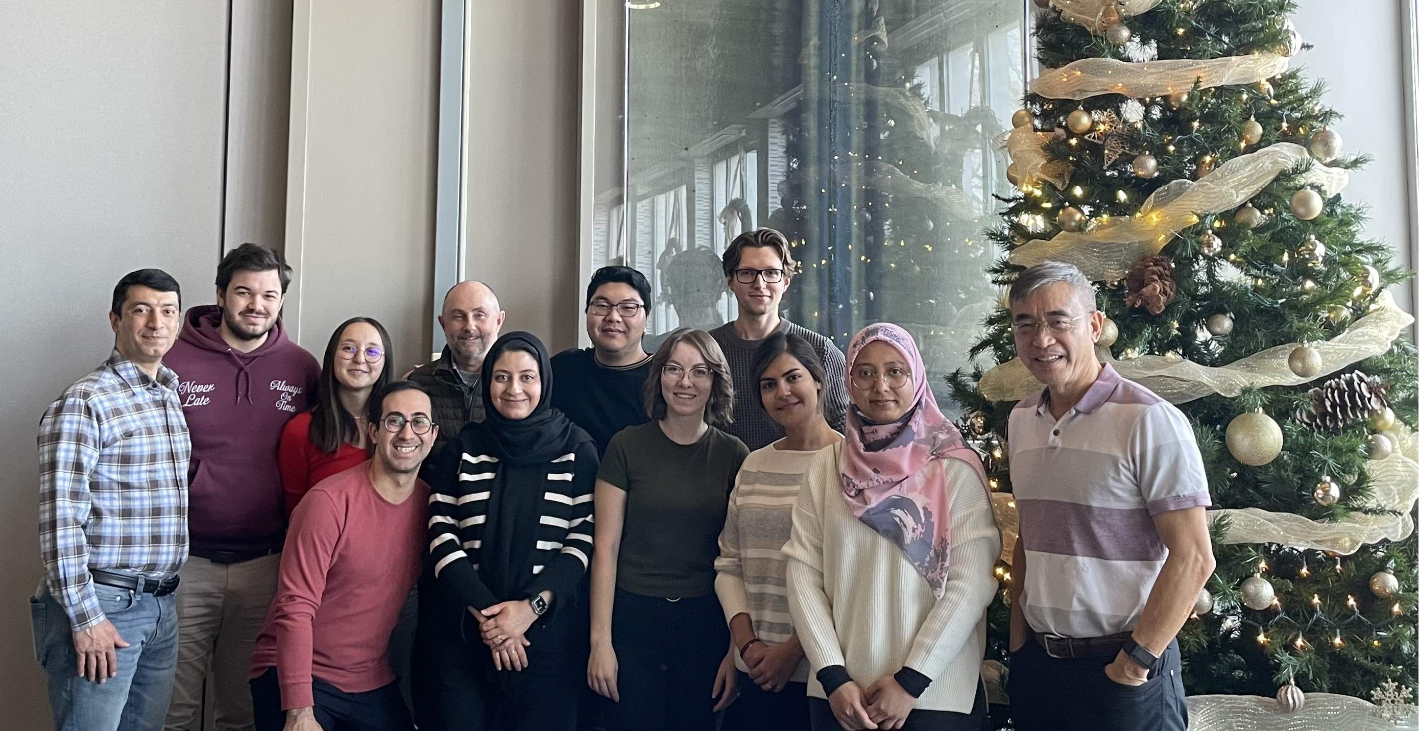 people in front of a christmas tree smiling